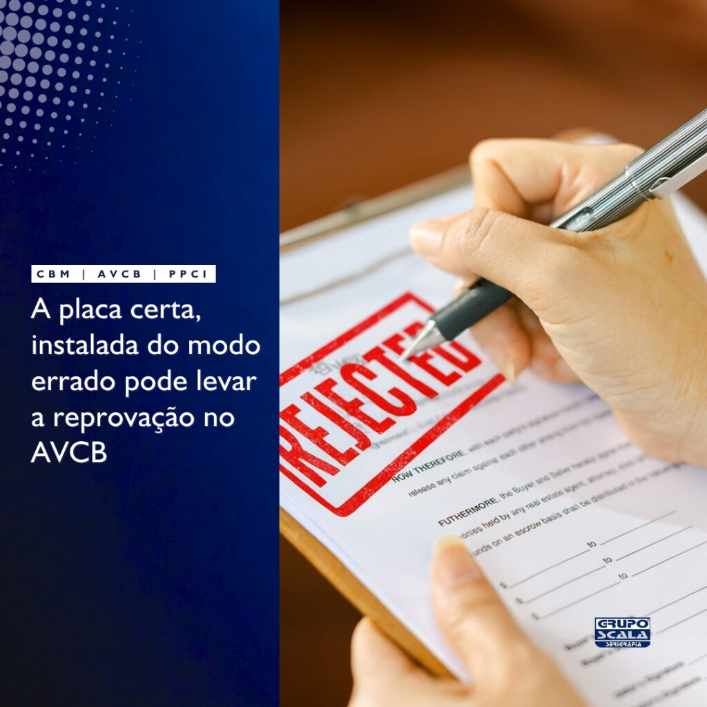 Exemplo de placa de rota de fuga instalada incorretamente fora da altura prevista na norma ABNT NBR 16820.